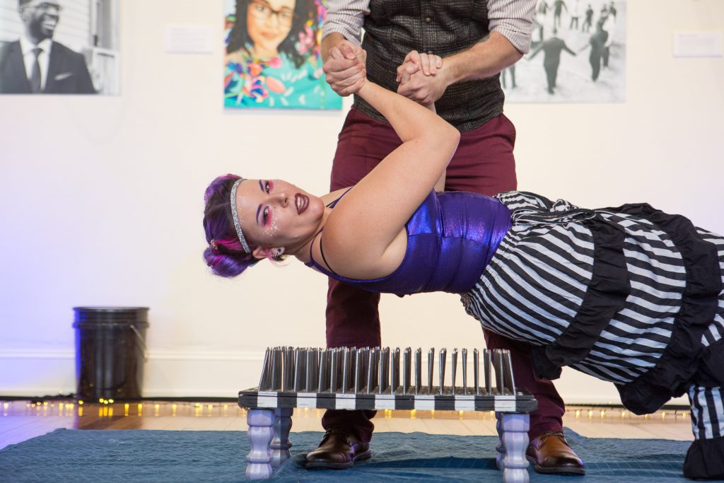 Sideshow artist Krystal Younglove laying on a bed of nails